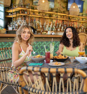 three women sitting at a table eating at a restaurant