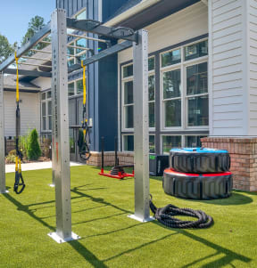 a home gym with tires and a swing set in the yard at Alta Vale, North Carolina, 27612