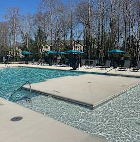 A large swimming pool with a slide and sun loungers.