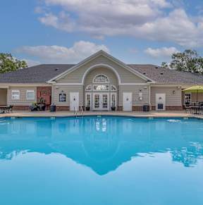 A large swimming pool in front of a house.