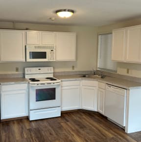 a kitchen with white cabinets and white appliances