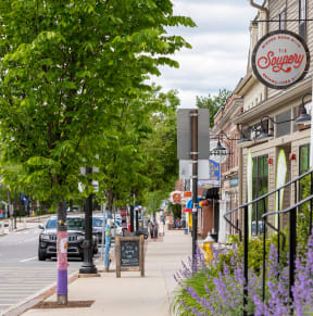 a city street with a blue building on the left and a tree on the right