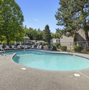 a resort style pool with chairs around it and trees