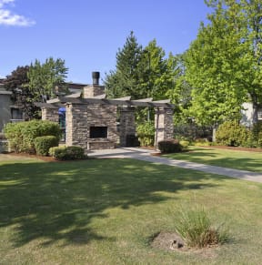 a stone building with a lawn and trees in front of it