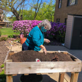 a woman is working in a raised garden bed