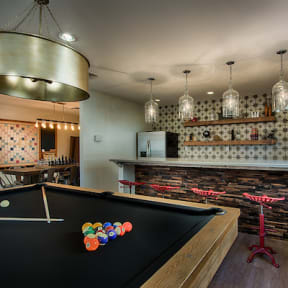 a game room with a pool table and bar