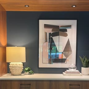 a table with a lamp and a picture on the wall