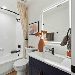 a bathroom with a white tub next to a toilet and a sink