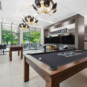 a games room with a foosball table and two televisions