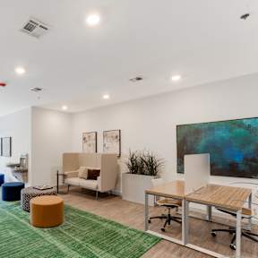 A modern office space with a green rug and various seating options.