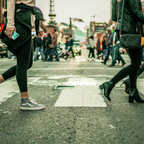 people crossing the street at a crosswalk in a city