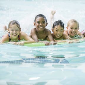 a group of children swimming in a swimming pool