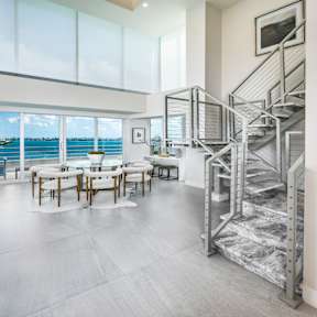 A modern interior with a staircase and a table with chairs.