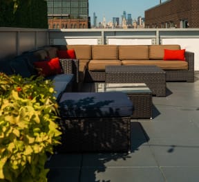 a roof top patio with furniture and a view of the city at 34 Berry, Brooklyn, NY, 11249