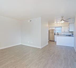 an empty living room and kitchen with a wood floor at Allora Phoenix Apartments, Phoenix, Arizona