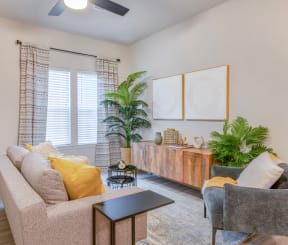 a living room with a couch and two chairs and a window