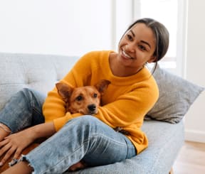 a woman sitting on a couch with her dog