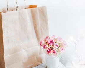 Brown shopping bag near flowers