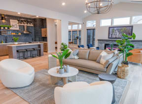 a living room with a couch and chairs and a kitchen