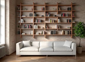 A white couch sits in front of a bookshelf filled with books.