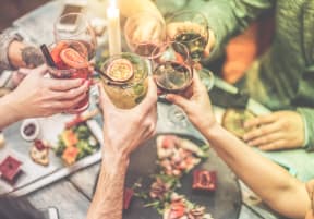 a group of people holding up wine glasses over a table