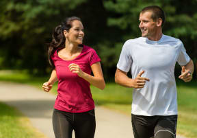 a man and a woman running in a park