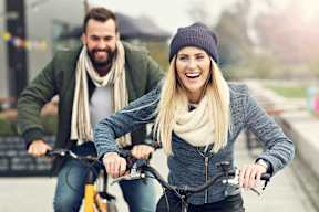 a man and a woman riding bikes down a road