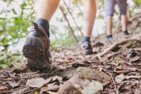 A person's feet in hiking boots stepping on a rocky trail. at Bridgwater, Greenwood Village, CO, 80111