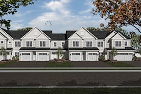 A row of houses with trees in front.