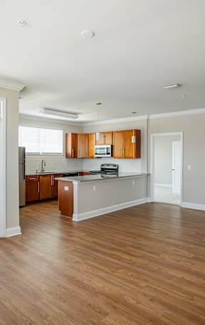 A large empty room with wooden floors and white walls.