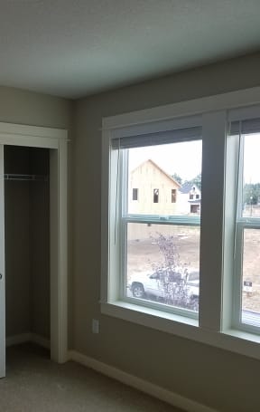 a bedroom with a large window and a closet