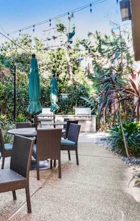 A patio with a table and chairs under green umbrellas.