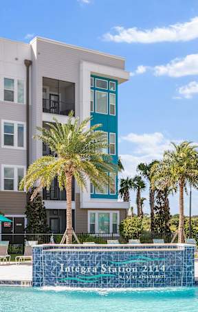 A modern apartment building with a pool in front.