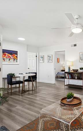 A living room with a rug, a couch, a dining table and chairs.