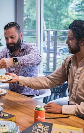 A group of people are gathered around a table eating food.