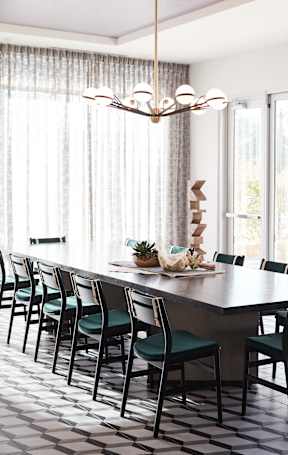 A kitchen with a marble island and a table with chairs.