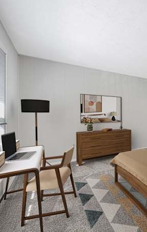 A bedroom with a bed, desk, and chair.