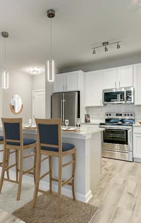an open kitchen with a granite counter top and stools
