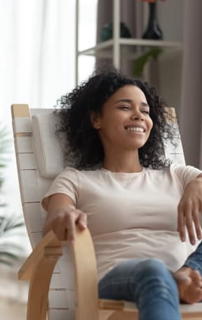 a woman sitting on a rocking chair in a living room