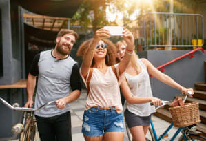 a group of people riding bikes and taking a picture with a cell phone at Edgemont Apartments, PRG Real Estate, Greenville, 29615
