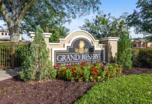 a sign that says grand reserve in front of plants and trees