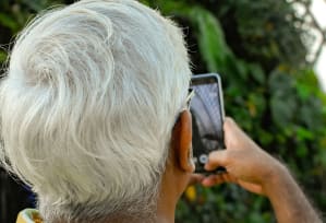 an older woman taking a picture of herself on a cell phone
