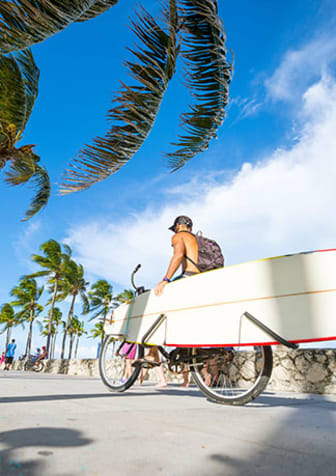 Man on bike with surfboard  at Bay Winds, Miami, FL