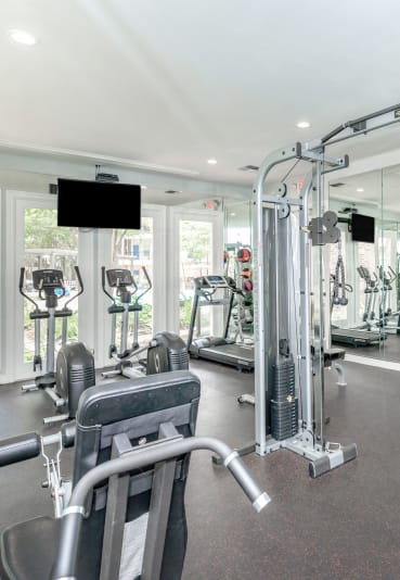 a gym with weights and cardio equipment and glass walls