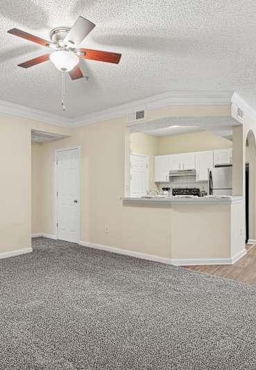 A room with a ceiling fan and carpeted floor.