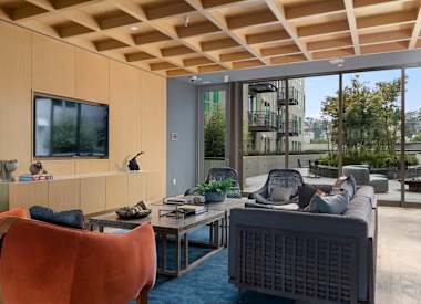 A living room with a television, a couch, and a chair.