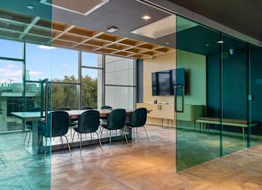 A conference room with a glass table and chairs.