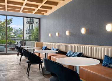 A modern cafe with black chairs and tables.