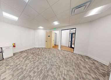 A room with a grey carpet and white walls.