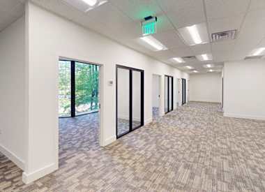 A long hallway with carpeted floors and white walls.